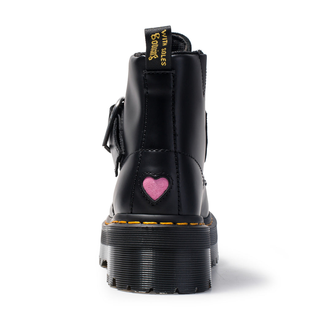 Black boot with a pink heart patch on a white background