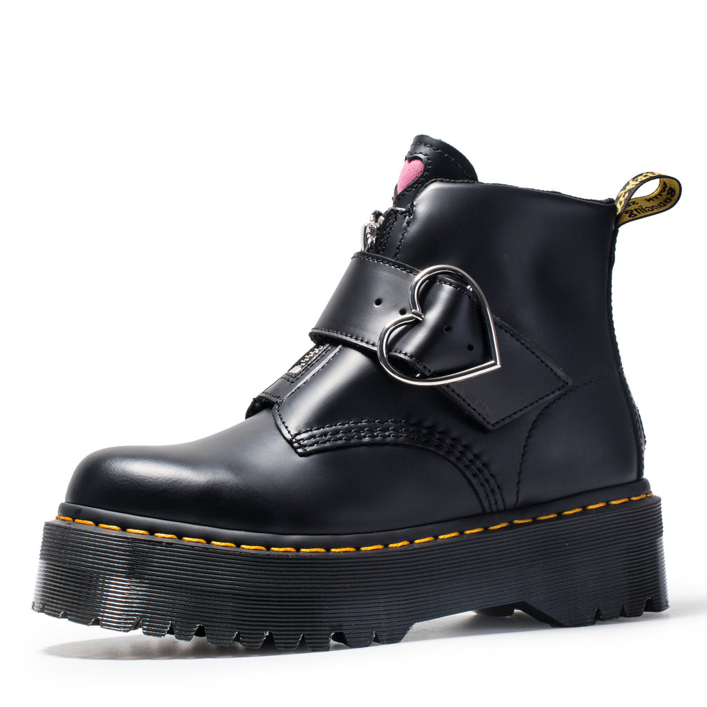 Black leather boot with buckle detail on a white background