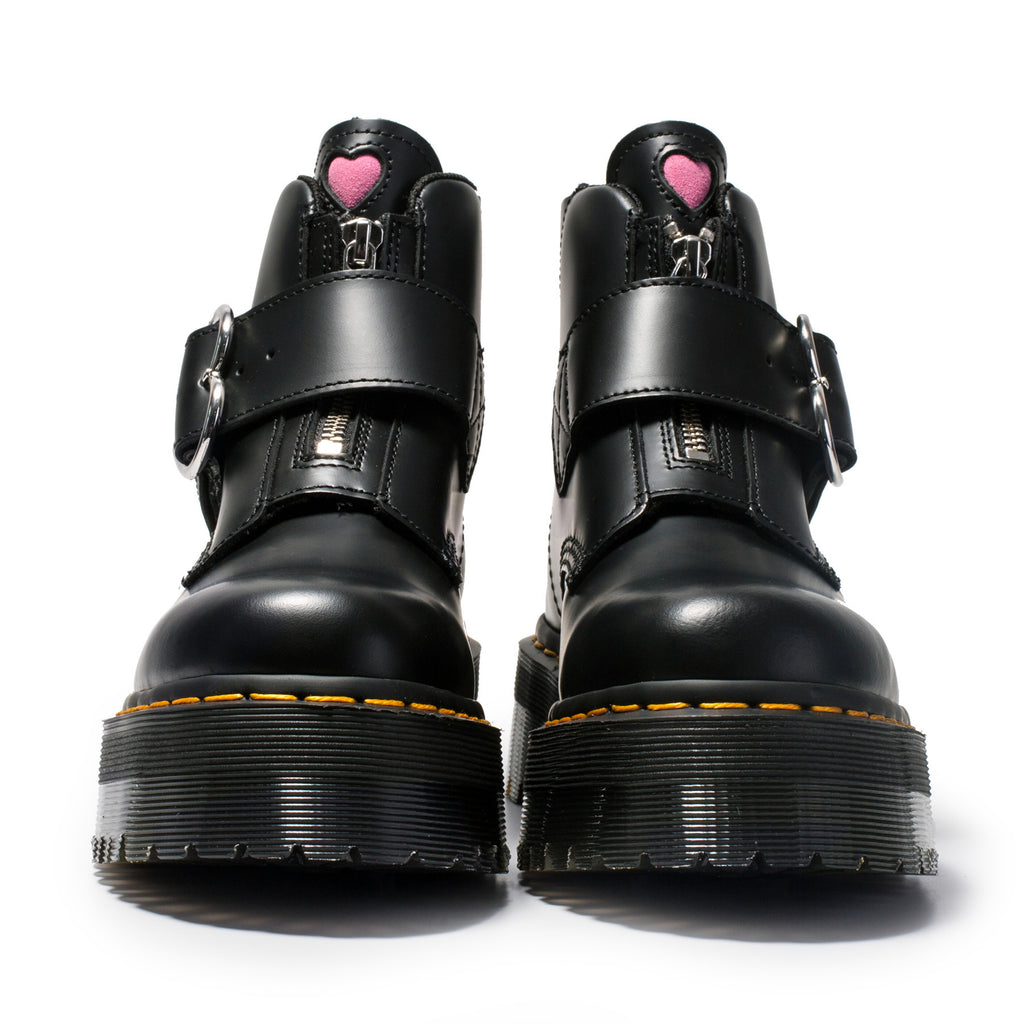 Black platform boots with heart details on a white background