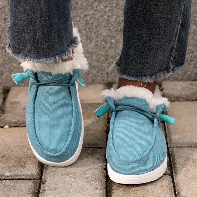 Blue slippers with white soles worn indoors on a stone floor.