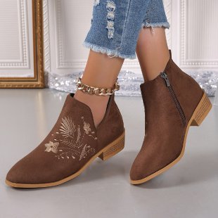 Brown ankle boots with floral embroidery on a light background