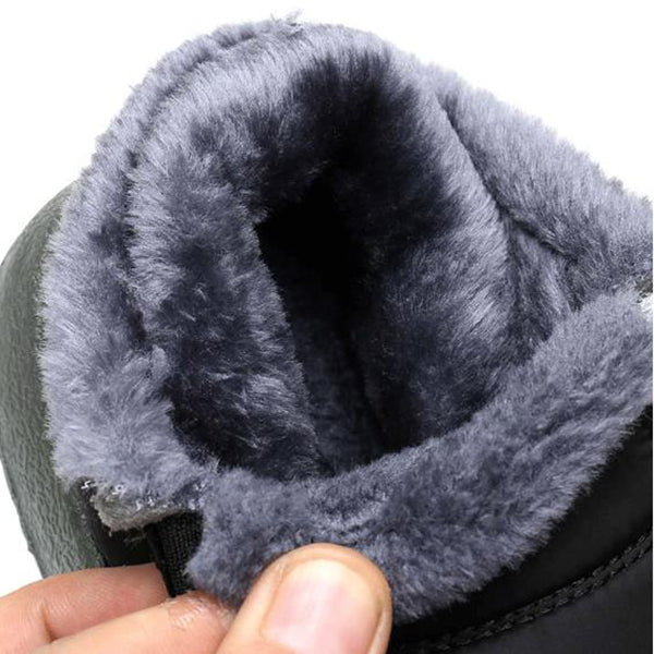 Close-up of a gray boot with fluffy lining held by a hand.