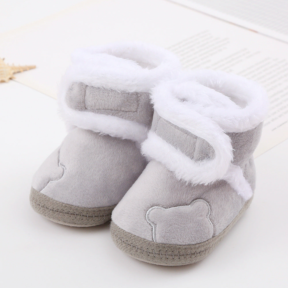 Gray baby boots with white fur trim on a light background