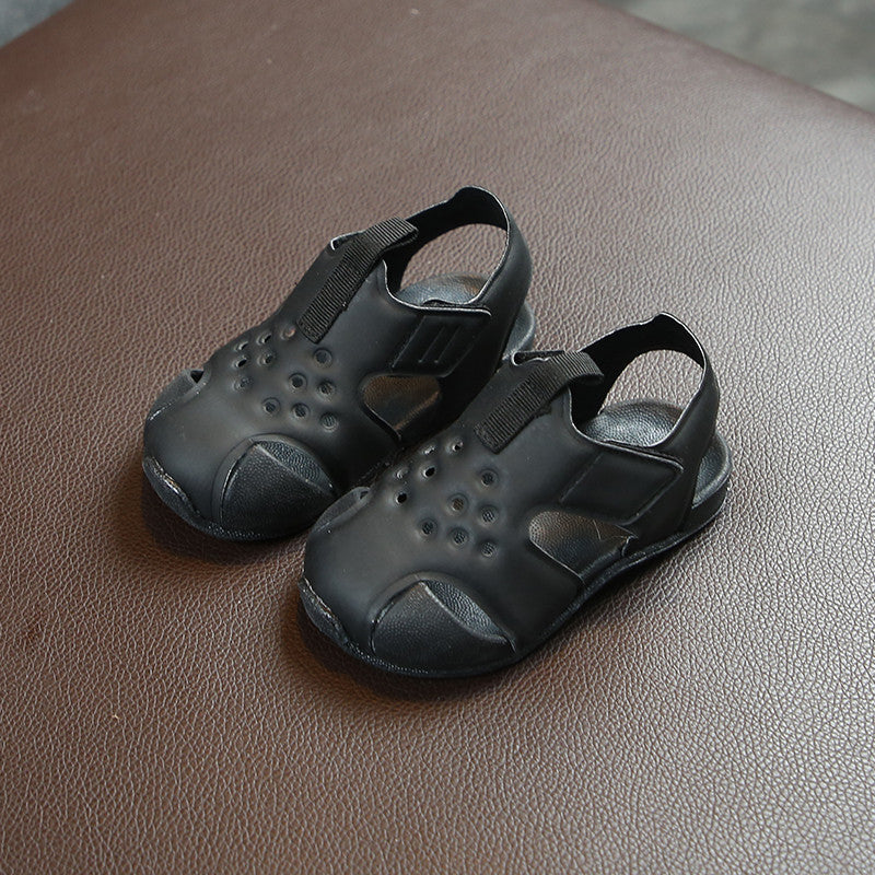 Pair of black sandals on a brown leather surface