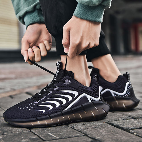 Person tying black and white running shoes on a pavement background