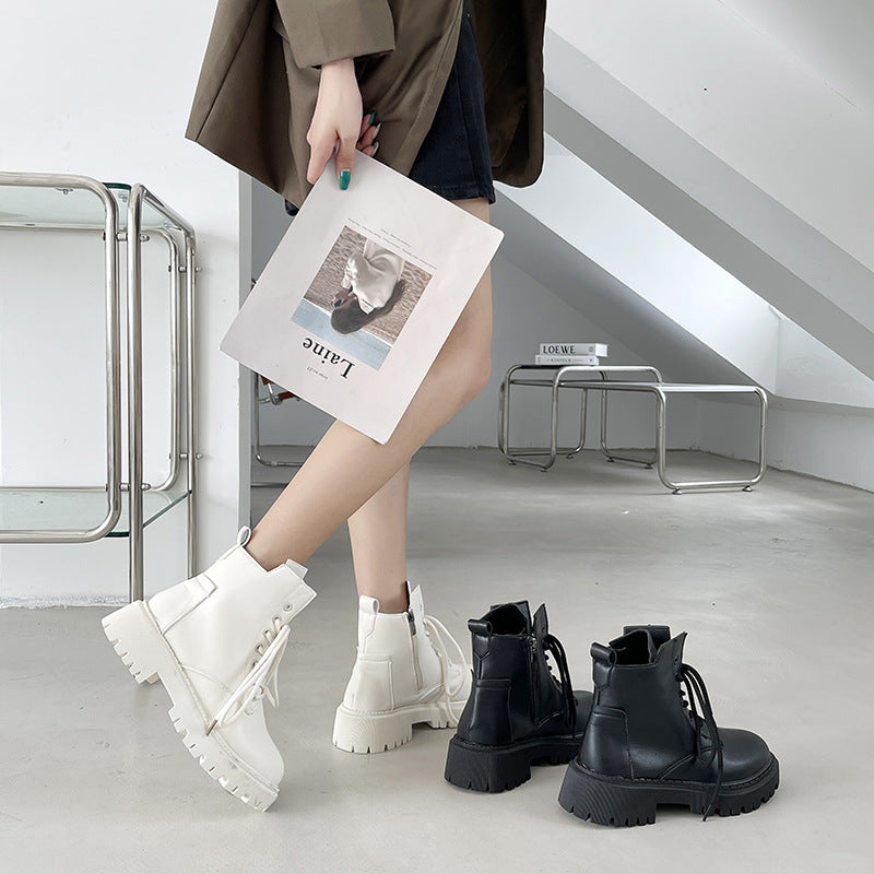 Person wearing white boots with black boots on the floor in a modern interior setting