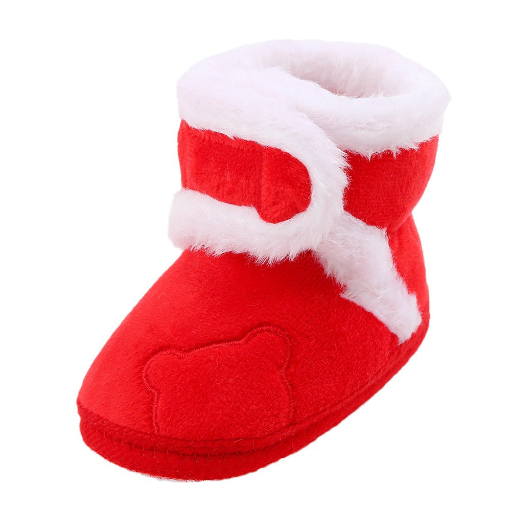 Red baby bootie with white fur trim on a white background