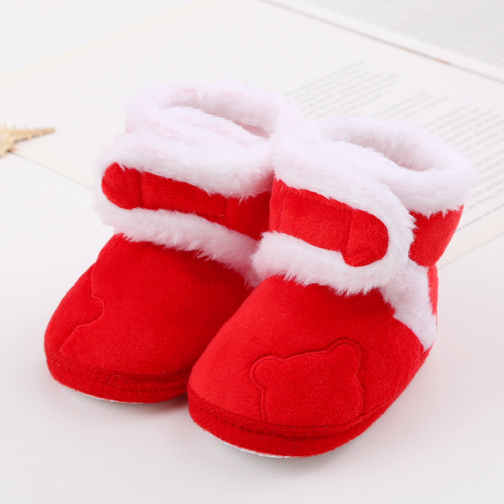 Red baby booties with white fur trim on a light background