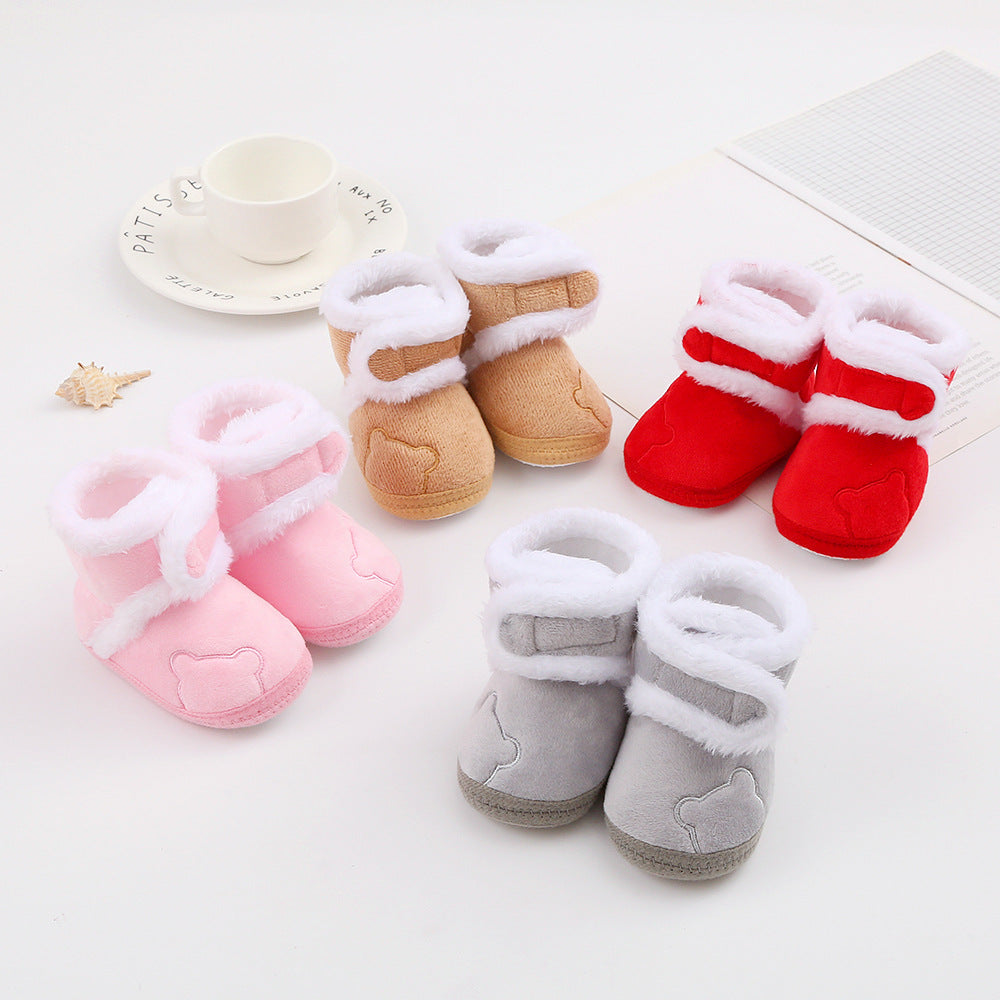 Set of baby boots in pink, brown, red, and gray on a light background