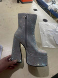 Silver platform boot with rhinestone embellishments on a light-colored surface.