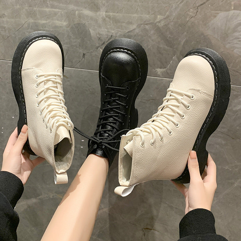 Two pairs of high-top sneakers, one beige and one black, held against a gray tiled floor.