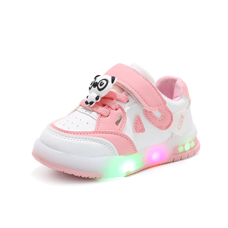 White and pink children's shoes with LED lights on a gray background