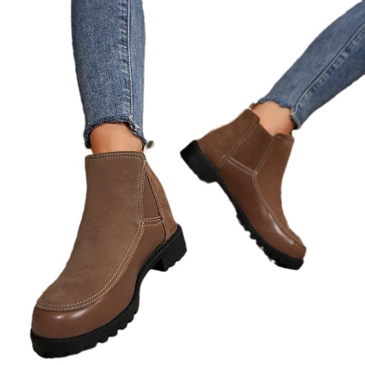 Brown ankle boots worn with blue jeans on a white background